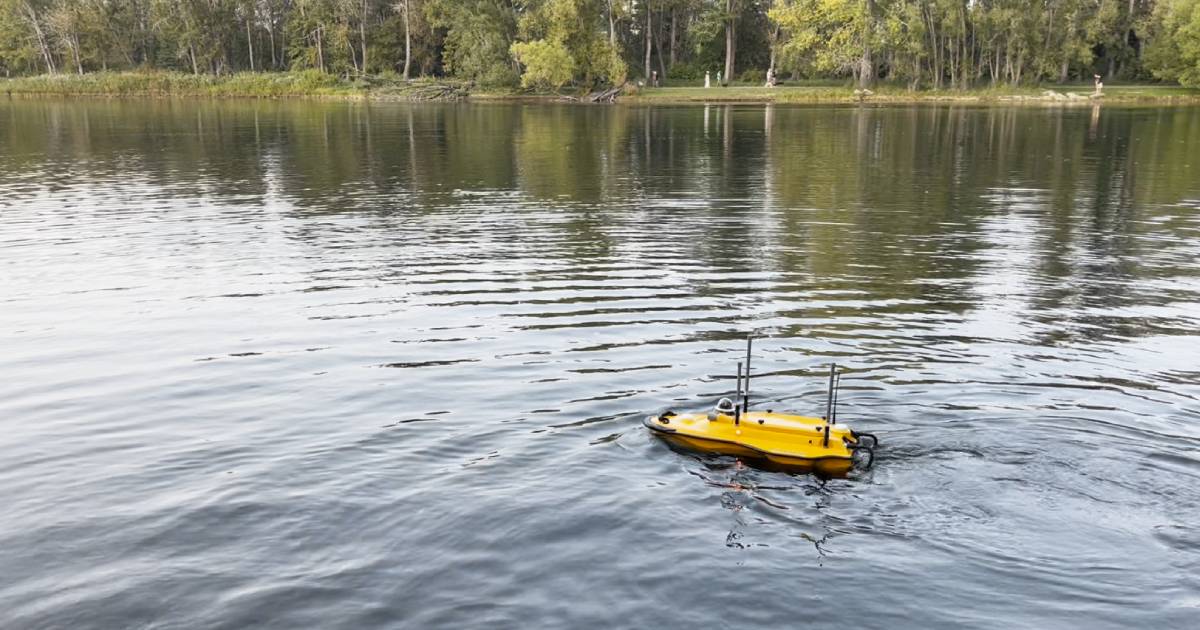 Convex Geomatics surveyor remotely operating a USV from shore on an Alberta river — eliminating crew water exposure